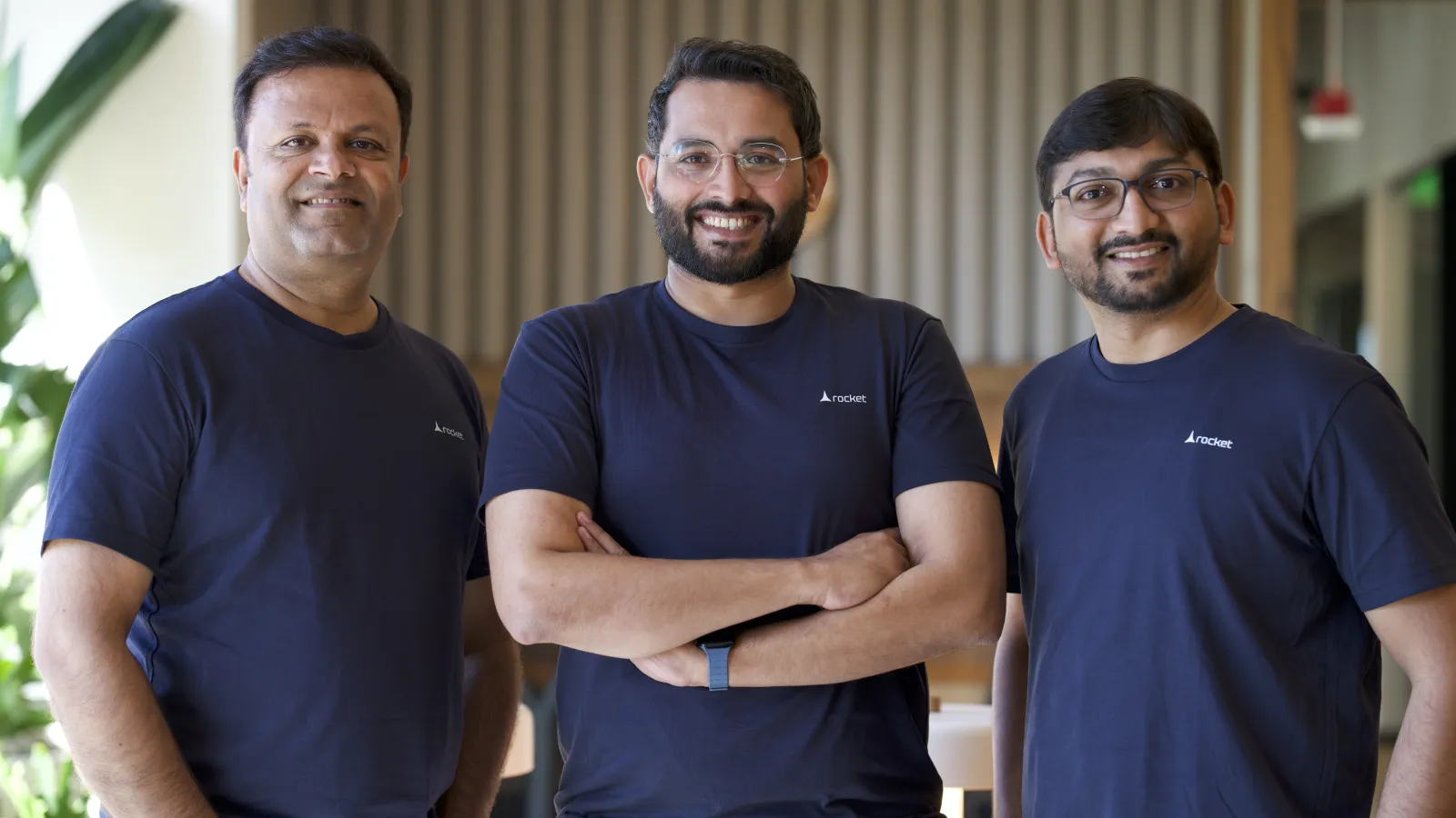 The Rocket founding team standing together in the company office, wearing navy Rocket t-shirts